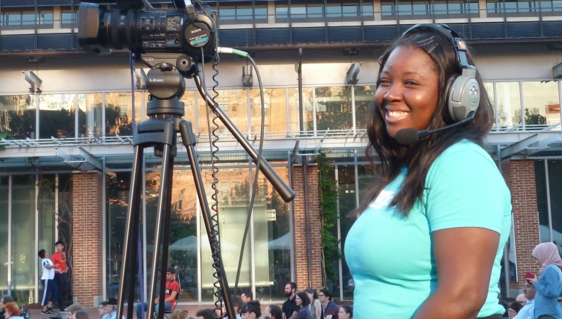 a woman smiling while operating a camera outside at the Constitution Center Mall