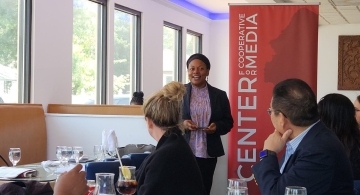 woman speaking publicly in front of a group of people