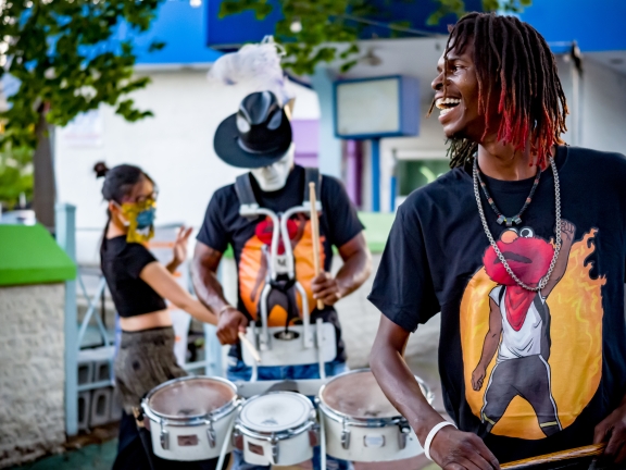 three members of a Philly drumline dancing and performing