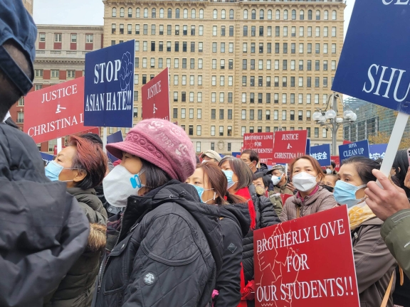 Protestors carrying signs at a protest against Asian hate