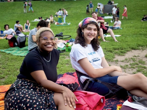 Two people posing on a blanket at a picnic