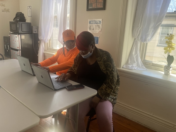 Two people sitting together working on laptops
