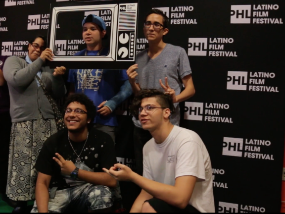 a group of people taking a photo in front of a backdrop that reads PHL Latino Film Festival