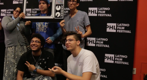 a group of people taking a photo in front of a backdrop that reads PHL Latino Film Festival